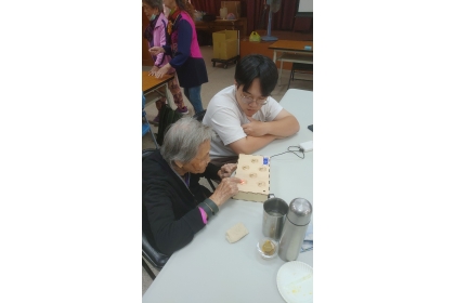 94歲高齡長者專注遊戲同時訓練眼睛和手指的協調反應。