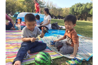 中興大學位於行政大樓與中興湖間的大草坪寬闊平整，安全性高，適合小孩成群奔跑嬉戲，民眾只需帶上野餐墊與輕食水果，大人小孩可輕鬆的度過半日時光。圖／中興大學提供