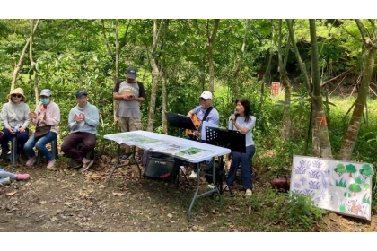 南投縣國姓鄉種瓜溪畔18日舉辦一場自然生態體驗活動，安排樂手以吉他彈唱自然之歌並合唱母親真偉大，表達對大地的感恩。（許秋容提供）