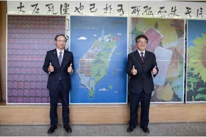 興大校長詹富智（右）與泓瀚科技董事長呂椬境（左）簽署產學合作備忘錄，後方為展示的彩色太陽能板。