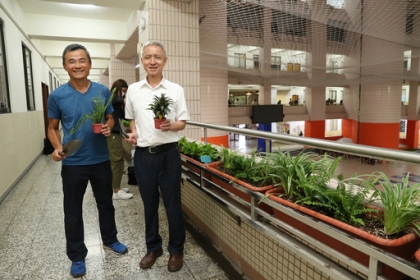 吳宗明教務長(右)與謝禮丞學務長與同學一起栽種盆栽。
